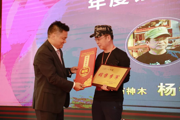 浙江省工艺美术大师、浙江中信红木董事长李忠信（左）为2018年度销售季军颁奖